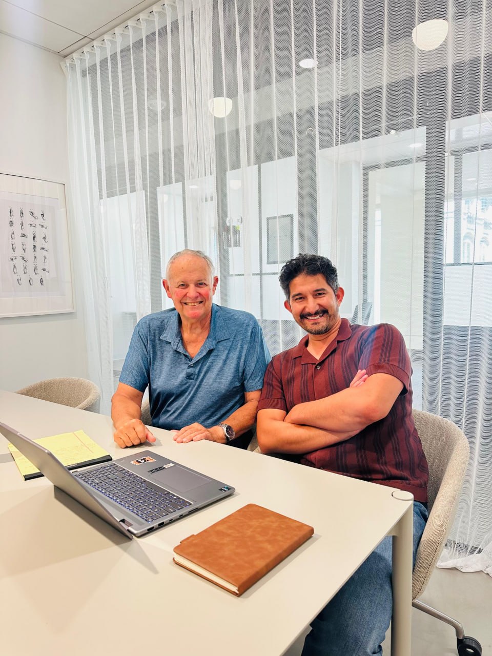 Mustafa Sharifi working with a client at a laptop.